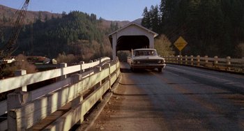 Movie still from “Five Easy Pieces” (1970), directed by Bob Rafelson – A car driving down a road under a covered bridge; Extreme Wide shot, High angle