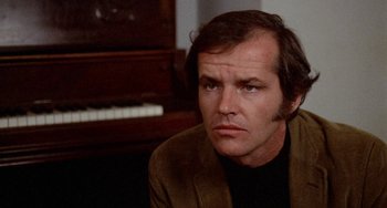 Movie still from “Five Easy Pieces” (1970), directed by Bob Rafelson – A person sitting in front of a piano; Close Up shot, Over the shoulder angle