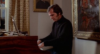 Movie still from “Five Easy Pieces” (1970), directed by Bob Rafelson – A man in a black shirt is playing a piano; Medium shot, Over the shoulder angle