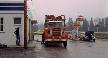 Movie still from “Five Easy Pieces” (1970), directed by Bob Rafelson – An orange truck parked in front of a gas station; Extreme Wide shot, High angle