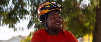 Movie still from “Good Boys” (2019), directed by Gene Stupnitsky – A young boy wearing a bike helmet and smiling; Close Up shot, Low angle