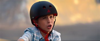 Movie still from “Good Boys” (2019), directed by Gene Stupnitsky – A young boy wearing a black helmet with a red band; Close Up shot, Over the shoulder angle