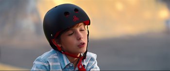 Movie still from “Good Boys” (2019), directed by Gene Stupnitsky – A young boy wearing a black helmet with red trim; Close Up shot, High angle
