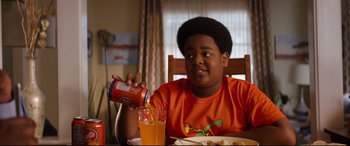 Movie still from “Good Boys” (2019), directed by Gene Stupnitsky – A young boy sitting at a table drinking orange juice; Medium shot, Over the shoulder angle
