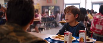 Movie still from “Good Boys” (2019), directed by Gene Stupnitsky – A young boy sitting at a table with a plate of food; Close Up shot, Over the shoulder angle
