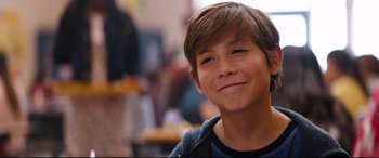 Movie still from “Good Boys” (2019), directed by Gene Stupnitsky – A young boy smiling for the camera with his mouth open; Close Up shot, Over the shoulder angle