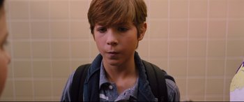 Movie still from “Good Boys” (2019), directed by Gene Stupnitsky – A young boy with a backpack is standing in a bathroom; Close Up shot, High angle
