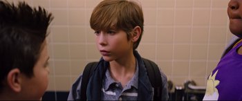 Movie still from “Good Boys” (2019), directed by Gene Stupnitsky – A young boy with a backpack is standing in a bathroom; Close Up shot, High angle