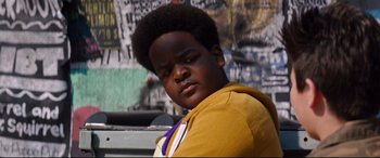 Movie still from “Good Boys” (2019), directed by Gene Stupnitsky – A young man with a very large afro is posing for a picture; Close Up shot, Over the shoulder angle