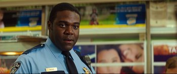 Movie still from “Good Boys” (2019), directed by Gene Stupnitsky – A police officer is standing in front of some pictures; Close Up shot, Over the shoulder angle