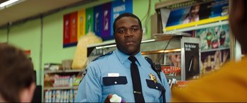 Movie still from “Good Boys” (2019), directed by Gene Stupnitsky – A police officer is holding a nintendo wii game controller; Medium shot, Over the shoulder angle