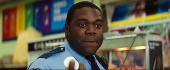 Movie still from “Good Boys” (2019), directed by Gene Stupnitsky – A man in uniform holding a wii controller; Close Up shot, Over the shoulder angle