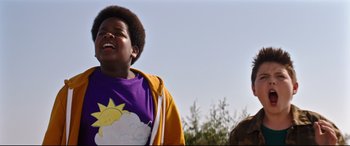 Movie still from “Good Boys” (2019), directed by Gene Stupnitsky – A young boy wearing a purple shirt with a sun and a cloud on it; Close Up shot, Low angle