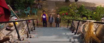 Movie still from “Good Boys” (2019), directed by Gene Stupnitsky – Three young boys standing on the steps of a house; Wide shot, High angle