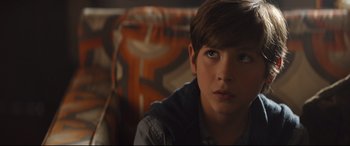 Movie still from “Good Boys” (2019), directed by Gene Stupnitsky – A young boy sitting on a couch looking into the distance; Close Up shot, Over the shoulder angle