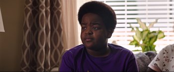Movie still from “Good Boys” (2019), directed by Gene Stupnitsky – A young man in a purple t - shirt looks at the camera; Close Up shot, Over the shoulder angle