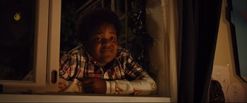 Movie still from “Good Boys” (2019), directed by Gene Stupnitsky – A young black boy leaning against a window sill; Medium shot, High angle