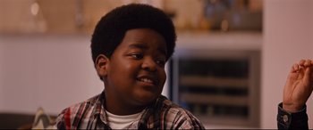 Movie still from “Good Boys” (2019), directed by Gene Stupnitsky – A young man with a beard and a plaid shirt is smiling for the camera; Close Up shot, Over the shoulder angle