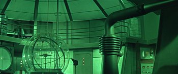 Movie still from “Forbidden Planet” (1956), directed by Fred M. Wilcox – The inside of a room with green lighting; Wide shot, Low angle
