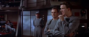 Movie still from “Forbidden Planet” (1956), directed by Fred M. Wilcox – A group of men standing next to each other in a room; Medium shot, Over the shoulder angle