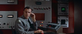 Movie still from “Forbidden Planet” (1956), directed by Fred M. Wilcox – A man sitting in front of a computer; Close Up shot, Low angle