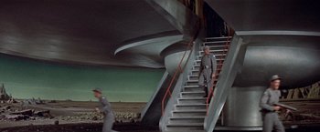 Movie still from “Forbidden Planet” (1956), directed by Fred M. Wilcox – A man walking down a set of stairs; Extreme Wide shot, Low angle