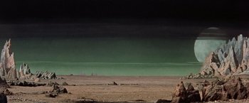 Movie still from “Forbidden Planet” (1956), directed by Fred M. Wilcox – A desert landscape with a green sky in the background; Extreme Wide shot, Low angle