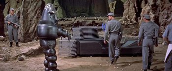Movie still from “Forbidden Planet” (1956), directed by Fred M. Wilcox – A man standing next to a fire hydrant in a field; Wide shot, Low angle