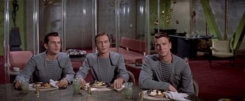 Movie still from “Forbidden Planet” (1956), directed by Fred M. Wilcox – A couple of men sitting at a table with food; Medium shot, High angle