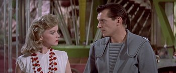 Movie still from “Forbidden Planet” (1956), directed by Fred M. Wilcox – A man and a woman standing next to each other; Medium shot, Low angle