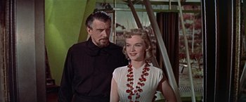 Movie still from “Forbidden Planet” (1956), directed by Fred M. Wilcox – A man standing next to a woman wearing a black shirt; Medium shot, Low angle