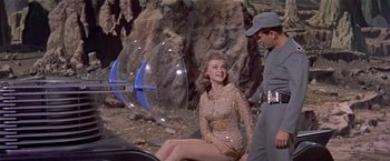 Movie still from “Forbidden Planet” (1956), directed by Fred M. Wilcox – A woman sitting on the ground next to a man; Medium shot, Over the shoulder angle
