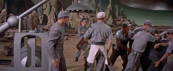 Movie still from “Forbidden Planet” (1956), directed by Fred M. Wilcox – A group of men standing next to each other on top of a hill; Wide shot, High angle
