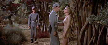 Movie still from “Forbidden Planet” (1956), directed by Fred M. Wilcox – A man and a woman standing next to each other in the woods; Medium shot, Over the shoulder angle
