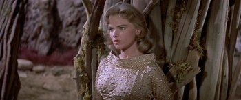 Movie still from “Forbidden Planet” (1956), directed by Fred M. Wilcox – A woman with blonde hair wearing a gold dress; Close Up shot, Low angle