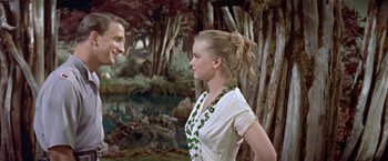 Movie still from “Forbidden Planet” (1956), directed by Fred M. Wilcox – A man and a woman standing next to each other in front of trees; Medium shot, Over the shoulder angle