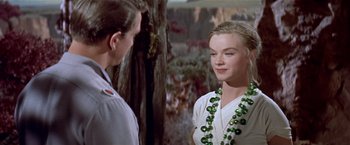 Movie still from “Forbidden Planet” (1956), directed by Fred M. Wilcox – A man and a woman wearing green necklaces; Close Up shot, Over the shoulder angle
