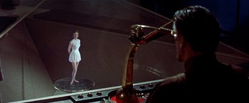 Movie still from “Forbidden Planet” (1956), directed by Fred M. Wilcox – A woman standing in front of a mirror in a room; Wide shot, Low angle