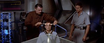 Movie still from “Forbidden Planet” (1956), directed by Fred M. Wilcox – A man sitting in front of another man in a chair; Medium shot, Over the shoulder angle