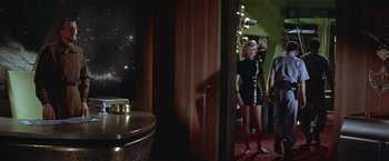 Movie still from “Forbidden Planet” (1956), directed by Fred M. Wilcox – A woman in a black dress standing in a room; Wide shot, Low angle