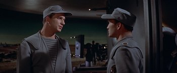 Movie still from “Forbidden Planet” (1956), directed by Fred M. Wilcox – Two men in uniforms are talking to each other; Medium shot, Over the shoulder angle