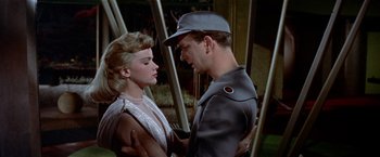 Movie still from “Forbidden Planet” (1956), directed by Fred M. Wilcox – A man and a woman are standing next to each other; Medium shot, Low angle
