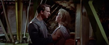 Movie still from “Forbidden Planet” (1956), directed by Fred M. Wilcox – A man and a woman are standing next to each other; Medium shot, Over the shoulder angle