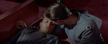 Movie still from “Forbidden Planet” (1956), directed by Fred M. Wilcox – A man laying on the ground next to another man; Close Up shot, High angle