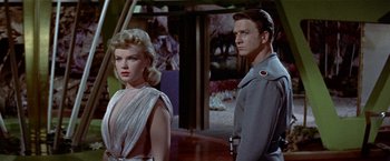 Movie still from “Forbidden Planet” (1956), directed by Fred M. Wilcox – A man and a woman standing next to each other; Medium shot, Low angle