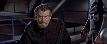 Movie still from “Forbidden Planet” (1956), directed by Fred M. Wilcox – An older man in a black shirt and black jacket; Close Up shot, Low angle