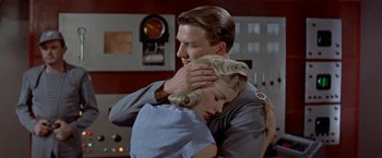 Movie still from “Forbidden Planet” (1956), directed by Fred M. Wilcox – A man and a woman hugging in a room; Medium shot, Low angle