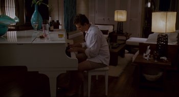 Movie still from “Forgetting Sarah Marshall” (2008), directed by Nicholas Stoller – A man sitting at a piano in a living room; Wide shot, High angle