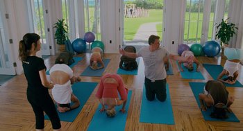 Movie still from “Forgetting Sarah Marshall” (2008), directed by Nicholas Stoller – A group of people doing yoga on mats in a room; Wide shot, High angle