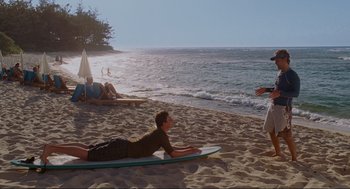 Movie still from “Forgetting Sarah Marshall” (2008), directed by Nicholas Stoller – A man on a surfboard on the beach; Wide shot, Over the shoulder angle
